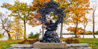 A large sculpture depicting musician Gordon Lightfoot surrounded by mini maple leaves representing his most famous songs