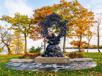 A large sculpture depicting musician Gordon Lightfoot surrounded by mini maple leaves representing his most famous songs