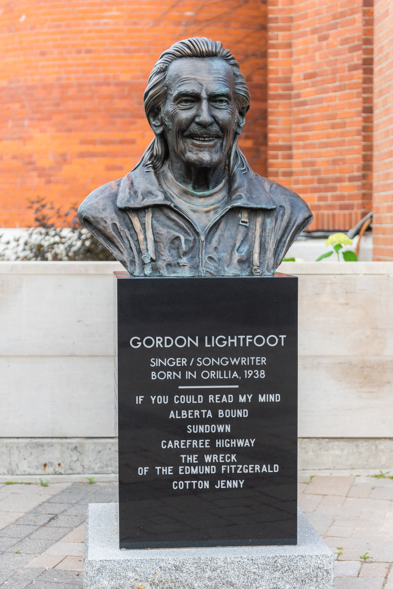 Bronze bust of Gordon Lightfoot in Orillia, mounted on a pedestal with inscriptions highlighting his career as a singer and songwriter born in the city.