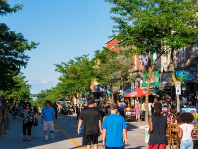 A street festival taking place in Downtown Orillia featuring extended patios and storefronts on a sunny day